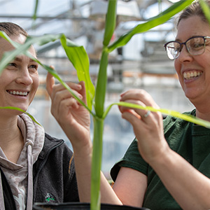 Two students with a plant