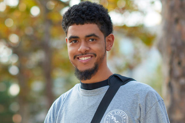 Saint Louis University student with backpack outside on campus