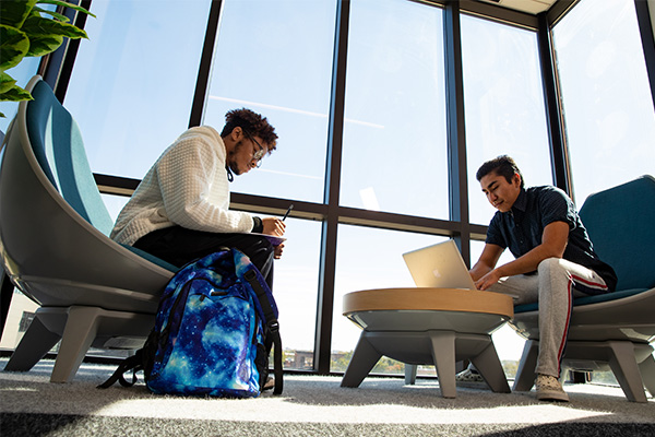 Two STLCC students sit in front of window in the library