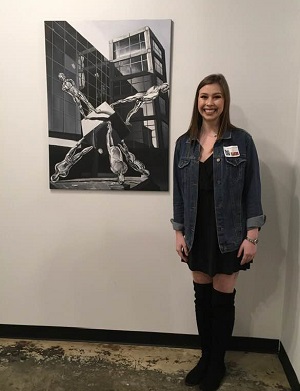 Rachael Kolumbus in front of her artwork
