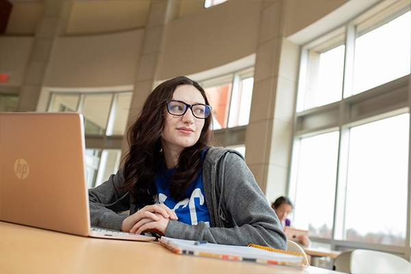 STLCC student uses laptop in the library