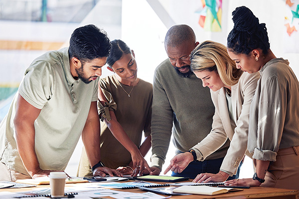 Group of staff members reviewing documents on a table
